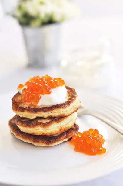 Delicious appetizer. Pancakes with sour cream and red caviar