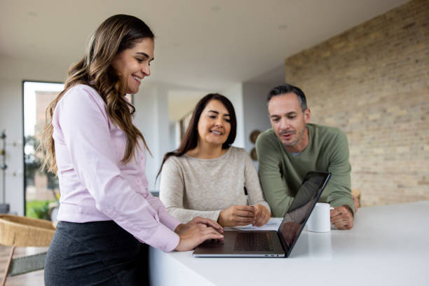 istock Happy real estate agent going through financial options with a couple 1490765741