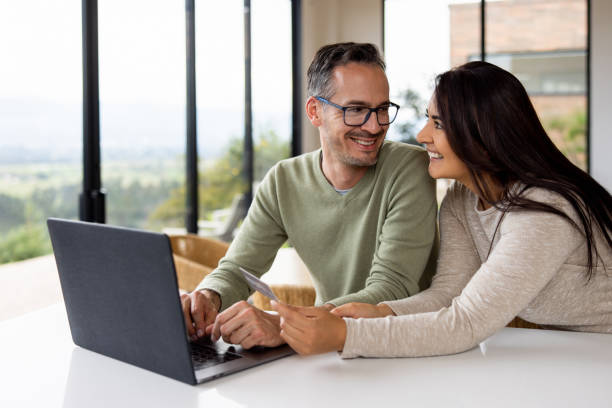 istock Happy couple at home shopping online using their credit card 1490765743