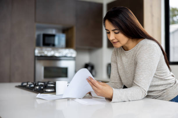 istock Woman reading a letter in the mail at the kitchen 1490765808