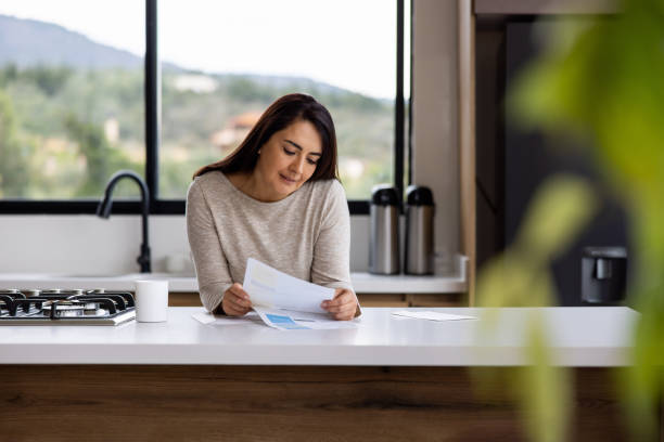istock Woman reading a utility bill in the kitchen while drinking her coffee 1490766681