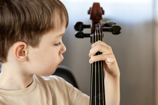 White 5 year old boy learning to play the cello