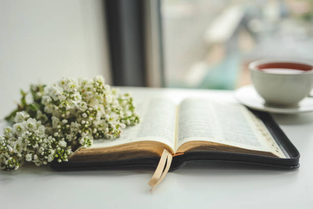 istock Open bible with flowers and a cup of tea on a white background 1490767343