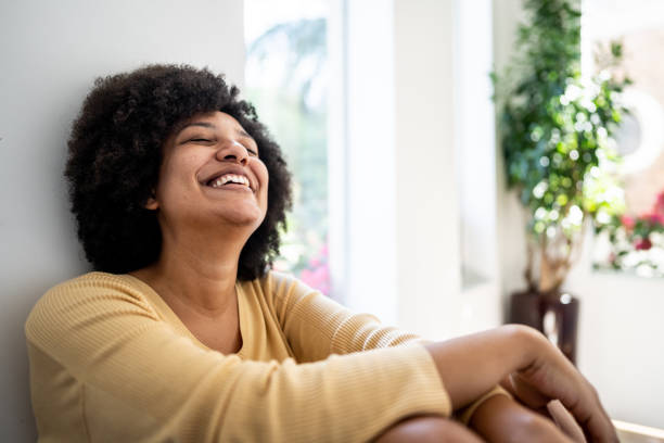 Happy young woman dreaming at home