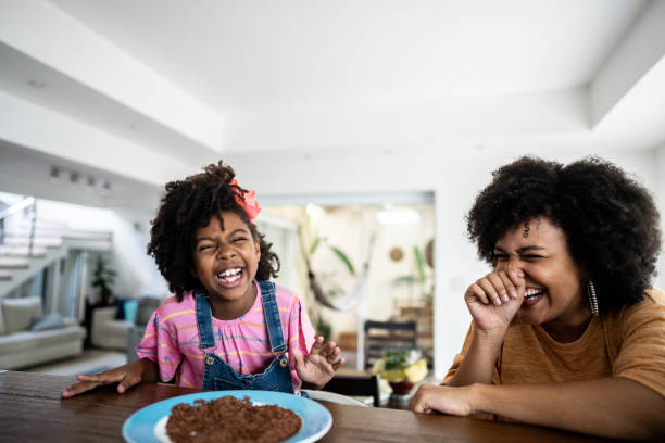 istock Mother and daughter laughing while talking at home 1490770386