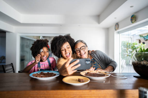 młoda kobieta robiąca selfie z matką i córką w domu - copy space sweet food food chocolate zdjęcia i obrazy z banku zdjęć