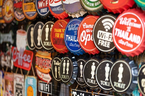 Bangkok, Thailand – January 02, 2023: A vibrant, eye-catching wall featuring an eclectic mix of signs and buttons in a variety of colors