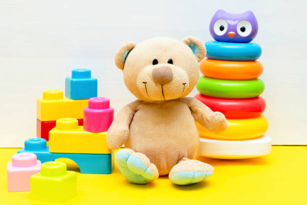 istock teddy bear with colorful pyramid, constructor, toy blocks for children play on white yellow background, baby's childhood development, Educational logic toys for toddler kid's concept 1490771875