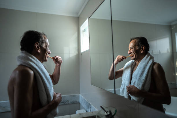 istock Senior man brushing his teeth on the bathroom at home 1490771885