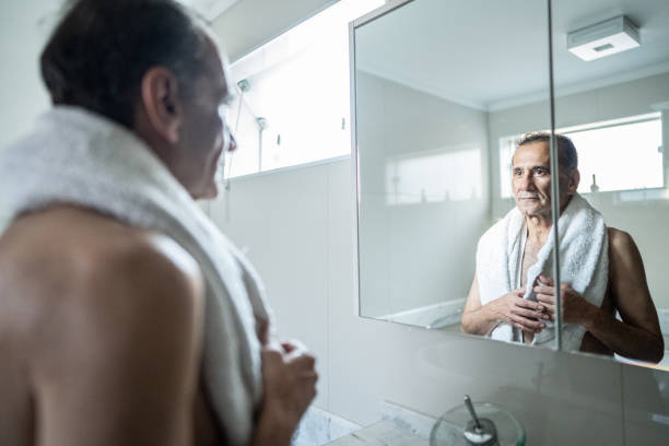 istock Senior man looking herself on mirror in the bathroom at home 1490771907