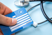 European health insurance card next to a medical stethoscope. Concept, EU document confirming the right to treatment outside the country, Travel insurance. Holiday insurance for Europeans.