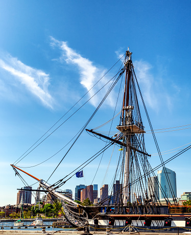 Boston, Massachusetts, USA - May 14, 2023: USS Constitution, also known as Old Ironsides, is a three-masted wooden-hulled heavy frigate of the United States Navy. She is the world's oldest ship still afloat. She was launched in 1797, one of six original frigates authorized for construction by the Naval Act of 1794. Constitution is most noted for her actions during the War of 1812 against the United Kingdom, when she captured numerous merchant ships and defeated five smaller British warships. Constitution was retired from active service in 1881 and served as a receiving ship until being designated a museum ship in 1907. Boston skyline in the background.