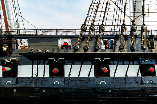 Boston, Massachusetts, USA - May 14, 2023: Side view of the USS Constitution, also known as Old Ironsides. The ship is a three-masted wooden-hulled heavy frigate of the United States Navy. She is the world's oldest ship still afloat. She was launched in 1797, one of six original frigates authorized for construction by the Naval Act of 1794. Constitution is most noted for her actions during the War of 1812 against the United Kingdom, when she captured numerous merchant ships and defeated five smaller British warships. Constitution was retired from active service in 1881 and served as a receiving ship until being designated a museum ship in 1907.