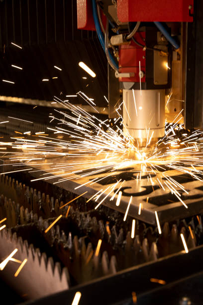 The fiber laser cutting machine cutting the sheet metal plate with the spark light The fiber laser cutting machine cutting the sheet metal plate with the spark light. High tech manufacturing concept. laser cutting metal stock pictures, royalty-free photos & images