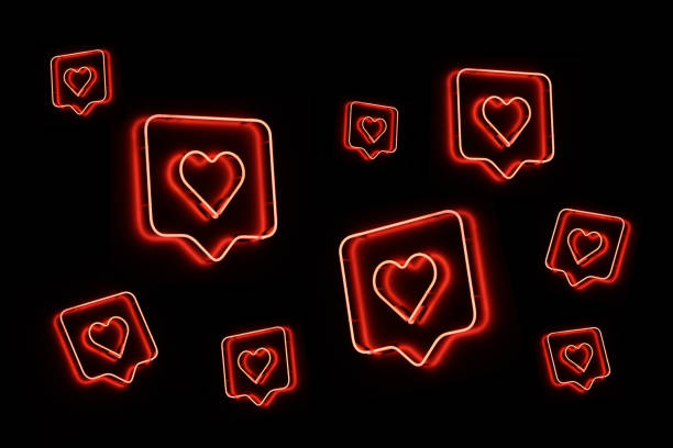 Neon heart shapes on black background stock photo