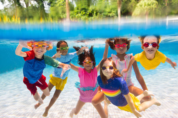 i bambini saltano in piscina. divertimento acquatico estivo. - swimming pool swimming summer underwater foto e immagini stock