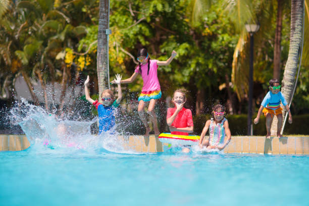 istock Kids jump into swimming pool. Summer water fun. 1490776783