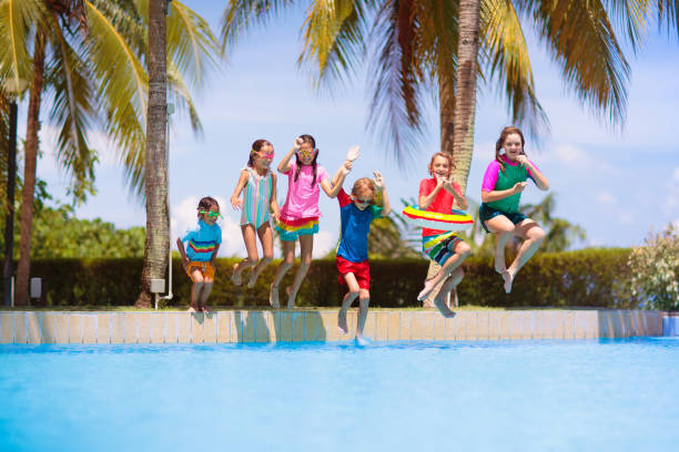 istock Kids jump into swimming pool. Summer water fun. 1490778574