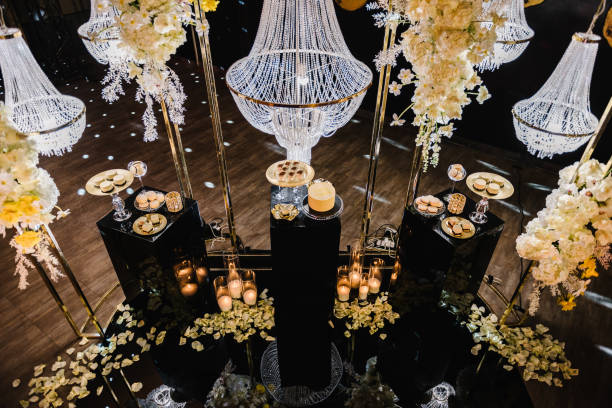 istock Delicious luxury wedding reception. Birthday Cake on party. Celebration concept. Candy bar. Table with sweets, candies, dessert. Arch with large chandelier, flowers, candles, rose petals on floor hall 1490780323
