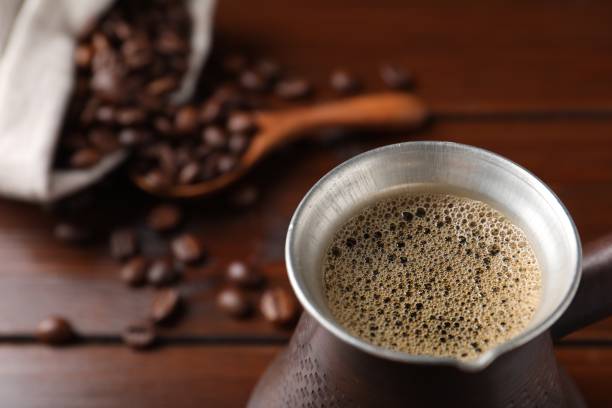 istock Turkish coffee in cezve on wooden table, closeup. Space for text 1490782615