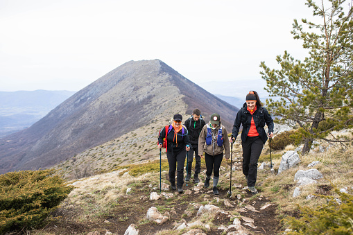 A group of hikers are on a hike in the mountains in early spring