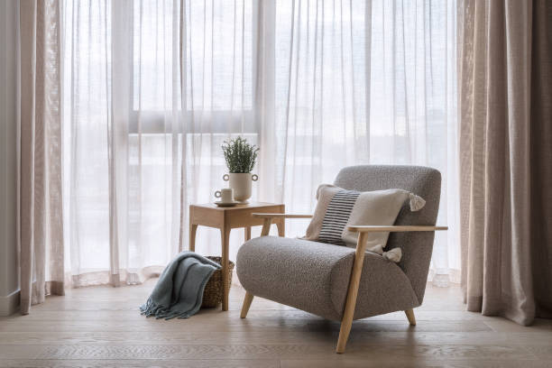 istock Grey armchair standing near coffee table with plaid in basket 1490783391