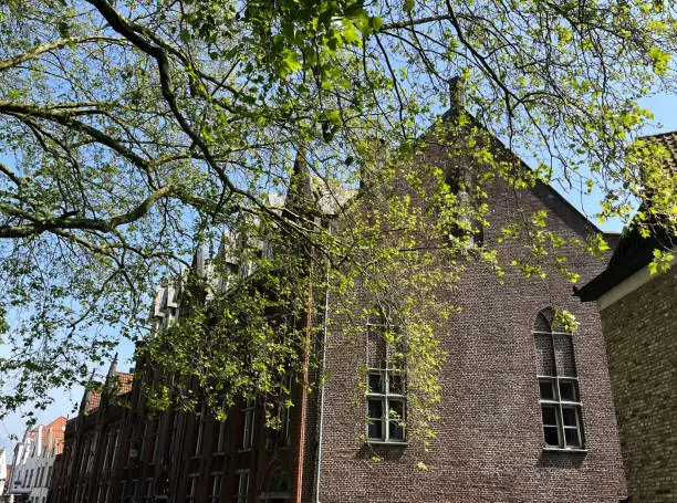 Photo of Traditional old-fashioned brick building in Minnewater park area in Brugge, Belgium, on spring sunny day, famous tourist attraction, popular landmark, classic cityscape for postcard or poster concept