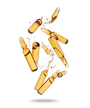 Group of crushed yellow ampoules in the air isolated on a white background