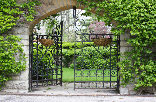A partially open gate, entrance to a garden
