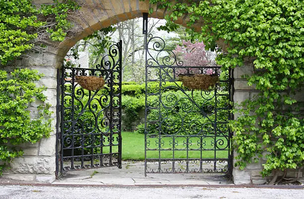 Photo of A partially open gate leading into a garden