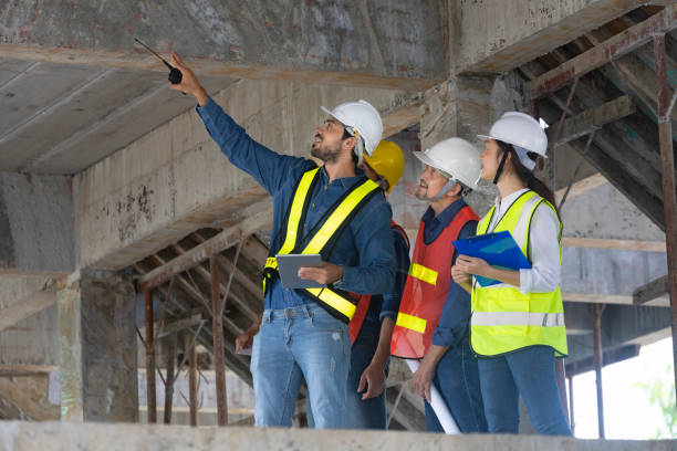 Team of engineer, architect, contractor and foreman meeting and consulting in construction building site for inspection in real estate development project industry and specification quality control equipo de ingenieros, arquitectos, contratistas y capataz que se reúnen y asesoran en el sitio de construcción para la inspección en la industria de proyectos de desarrollo inmobiliario y el concepto de control de calidad de especificación