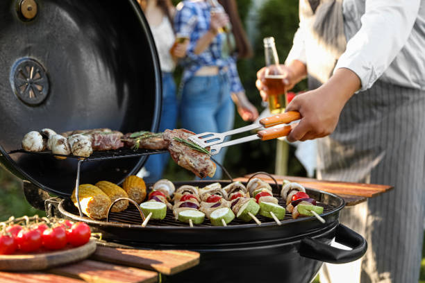 istock Man with drink cooking meat and vegetables on barbecue grill outdoors, closeup 1490791482