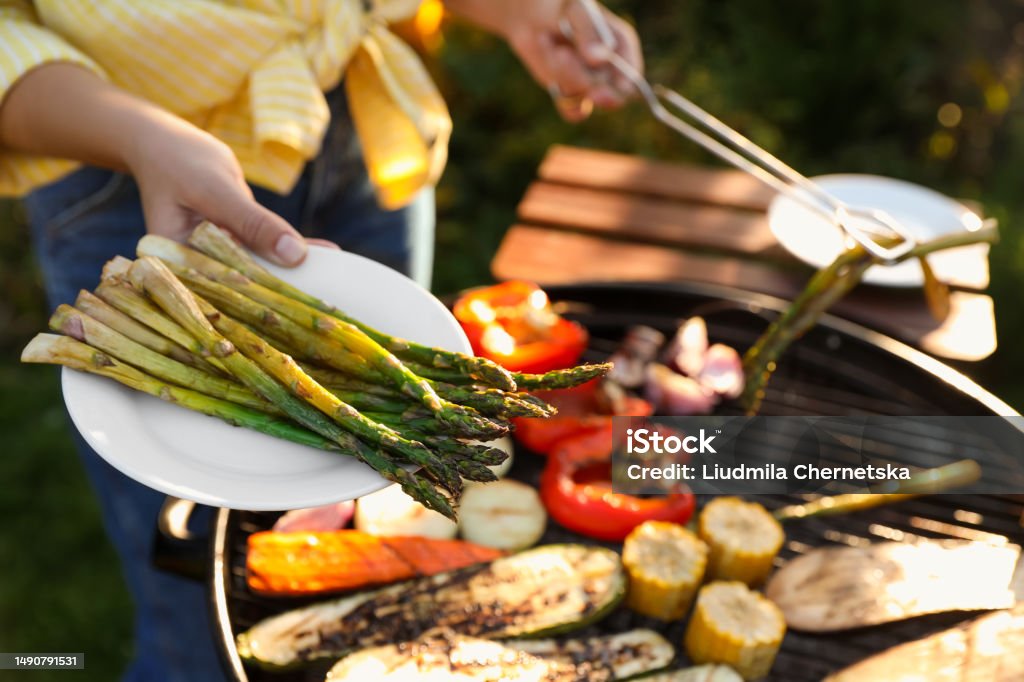 Woman cooking vegetables on barbecue grill outdoors, closeup Barbecue - Social Gathering Stock Photo