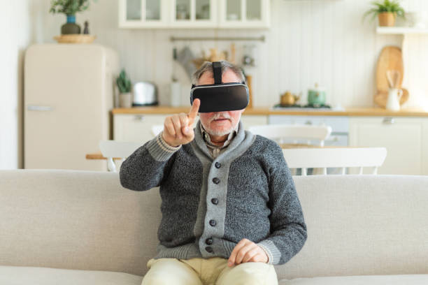 istock Excited mature senior man wearing using virtual reality metaverse VR glasses headset at home. Grandfather touching air during VR experience on virtual reality helmet. Simulation hi-tech videogame. 1490793592
