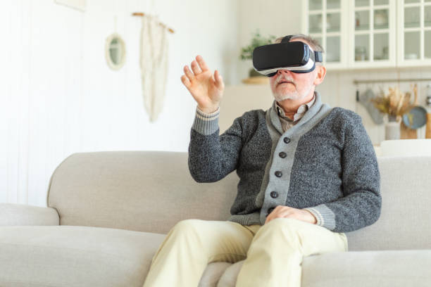 istock Excited mature senior man wearing using virtual reality metaverse VR glasses headset at home. Grandfather touching air during VR experience on virtual reality helmet. Simulation hi-tech videogame. 1490793610