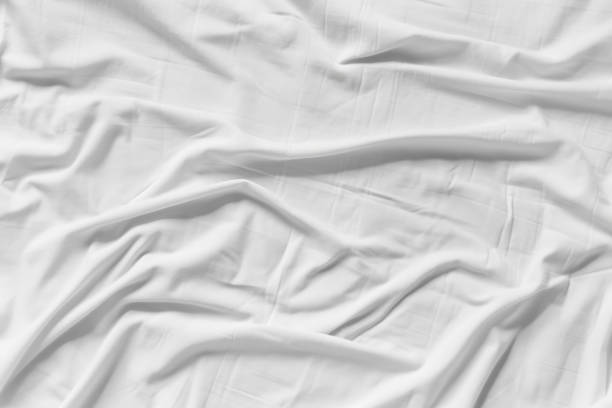 istock White wrinkled fabic texture rippled surface,Close up unmade bed sheet in the bedroom after night sleep Soft focus 1490794499
