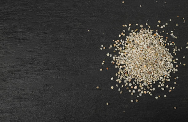 istock Crushed Quartz Pile, White Stone Pieces, Grit Sand, Decorative Rocks Texture on Black Background 1490796075