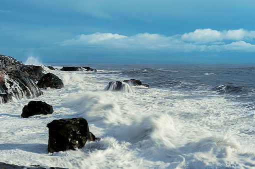 Large ocean waves crashing on rocky pacific shore.\n\nTaken in Santa Cruz, California, USA