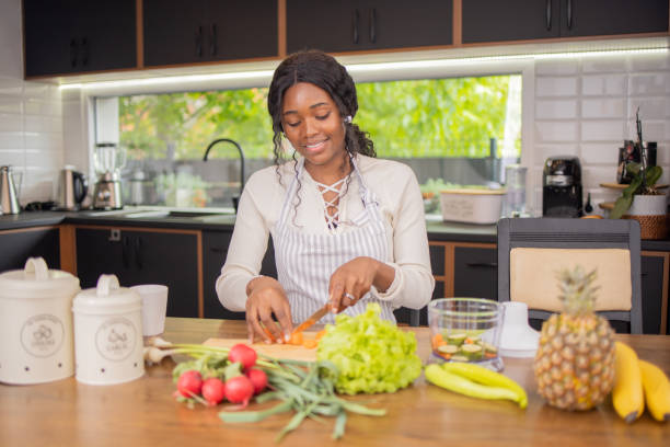 istock Happy young woman is preparing a meal in the kitchen 1490796806