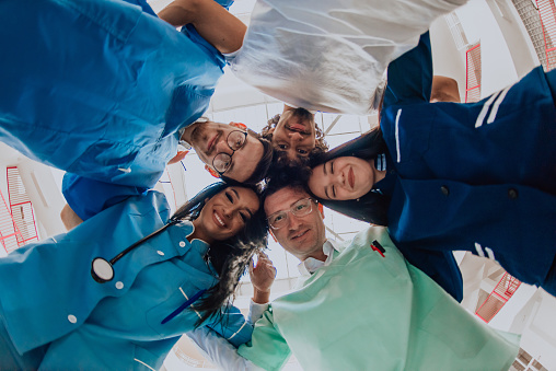 Group of doctors a medical nurse, and a surgeon are captured in a heartfelt embrace, showcasing their unity, teamwork, and profound connection in the healthcare field