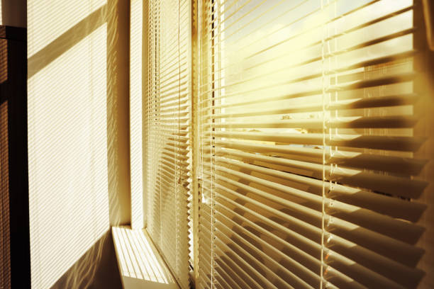 istock Stylish window with horizontal blinds in room 1490803443