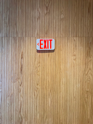 Exit sign on a wooden panel wall