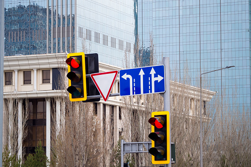Traffic light and traffic sign, a bridge and modern office buildings in the background.