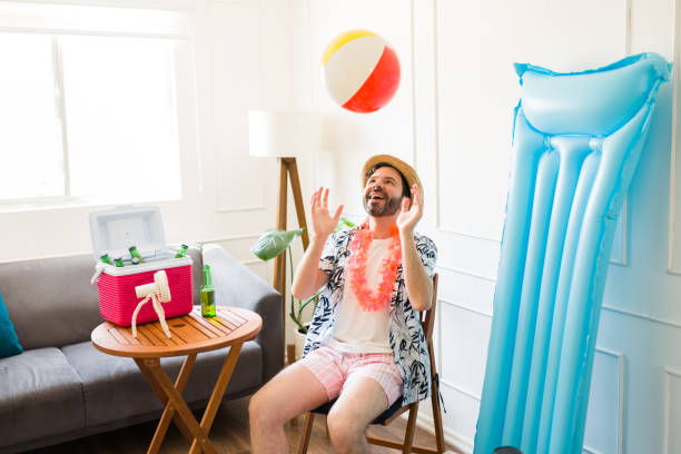 istock Excited man playing with a beach ball at home during staycations 1490809158