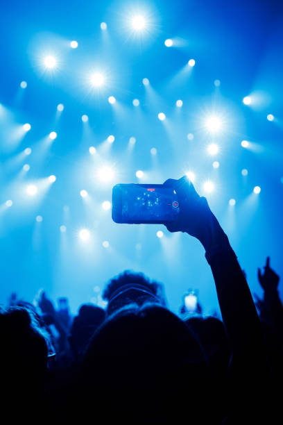 istock People at concert shooting video or photo using mobile phones. 1490811331
