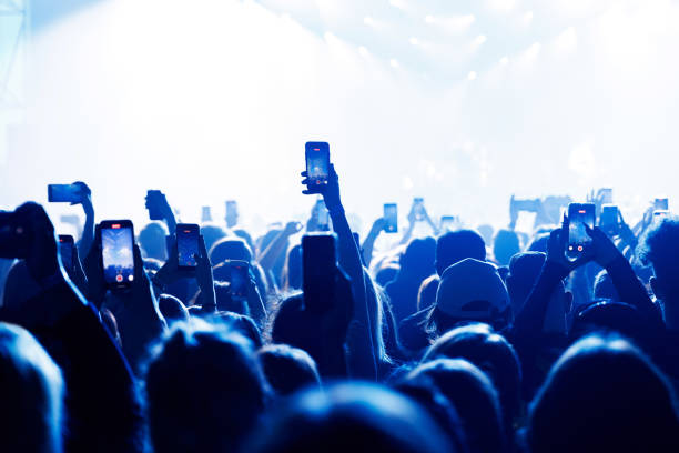 istock People at concert shooting video or photo using mobile phones. 1490811346