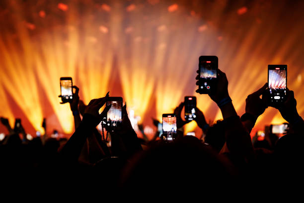 コンサートで携帯電話を使ってビデオや写真を撮影する人々。 - music festival outdoors popular music concert spectator ストックフォトと画像