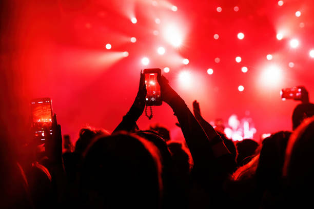 コンサートで携帯電話を使ってビデオや写真を撮影する人々。 - music festival outdoors popular music concert spectator ストックフォトと画像