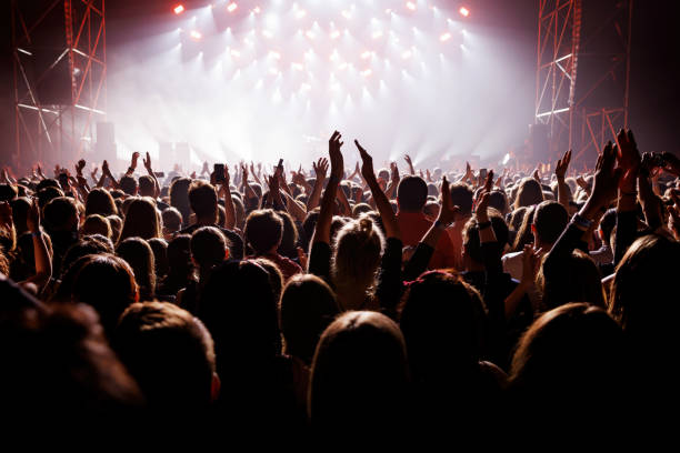 istock Happy people with raised hands at a music concert. 1490811435