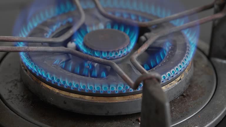 Slow motion close-up of igniting kitchen cooking gas burning fire stove top